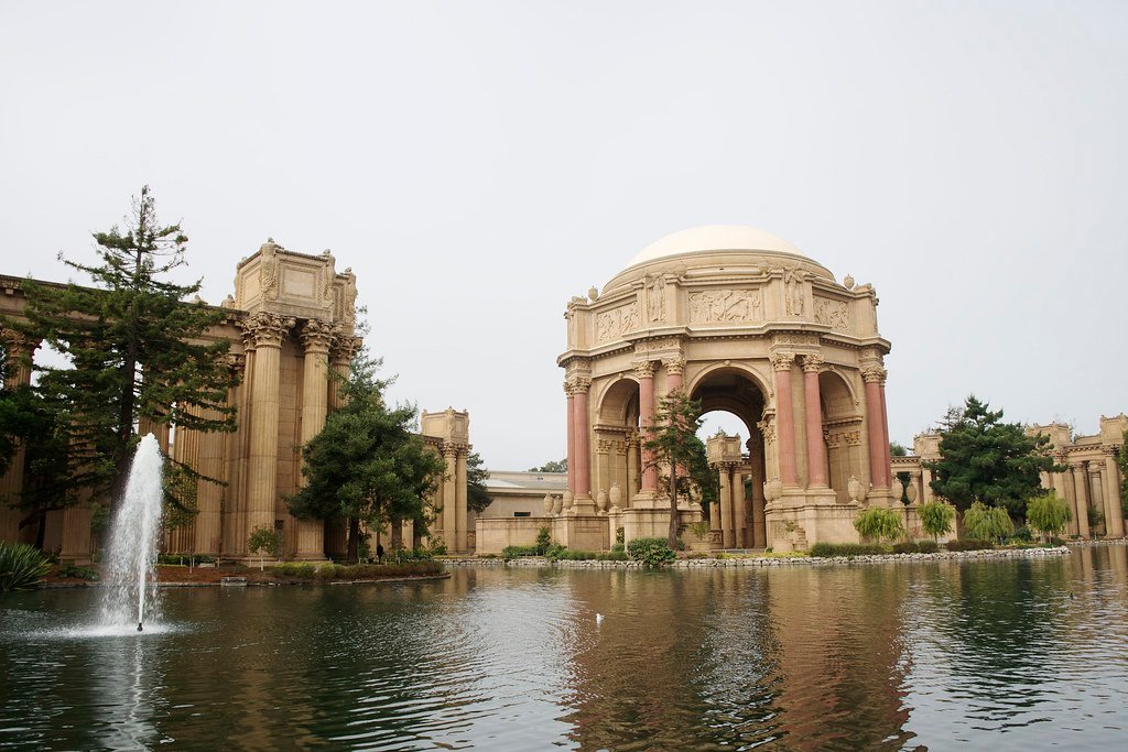 O Exploratorium com uma rotunda abobadada e uma fonte em um lago reflexivo. Imagem para ilustrar post sobre museus em San Francisco.